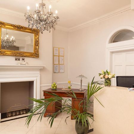 Montcalm Brewery Townhouse Hotel Лондон Екстериор снимка The photo shows a stylish reception area. There is a decorative chandelier hanging from the ceiling, providing elegant lighting. A large, ornate mirror is mounted on the wall beside the fireplace, which features a simple, classic design. In front of 