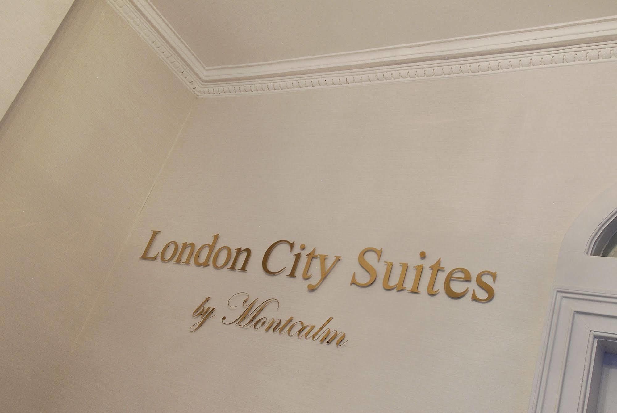 Montcalm Brewery Townhouse Hotel Лондон Екстериор снимка The photo shows a wall display featuring the text "London City Suites" in a bold, gold-colored font. Below that, the words "by Montcalm" are written in a smaller, elegant style. The background appears to be a neutral-colored wall, possibly in a hotel