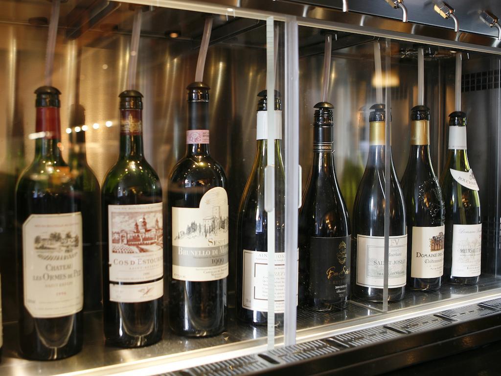 Montcalm Brewery Townhouse Hotel Лондон Екстериор снимка The photo depicts a selection of wine bottles displayed in a wine fridge or cooler. The bottles are lined up behind a glass panel, showcasing various types of wine, likely including both red and white varieties. Each bottle has a distinctive label, i