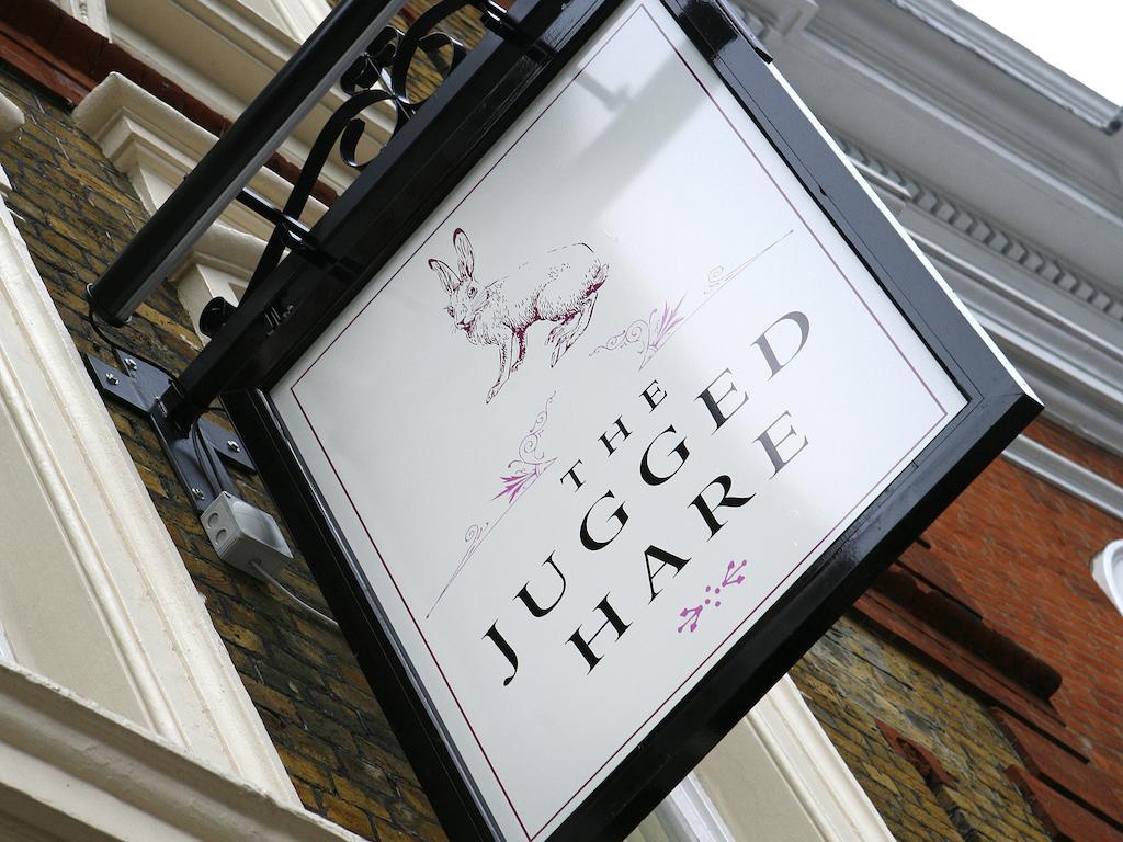 Montcalm Brewery Townhouse Hotel Лондон Екстериор снимка The photo shows a hanging sign for a place called "The Jugged Hare." The design features an illustration of a hare, along with the name displayed prominently in bold letters. The overall aesthetic combines an elegant font with delicate floral accents