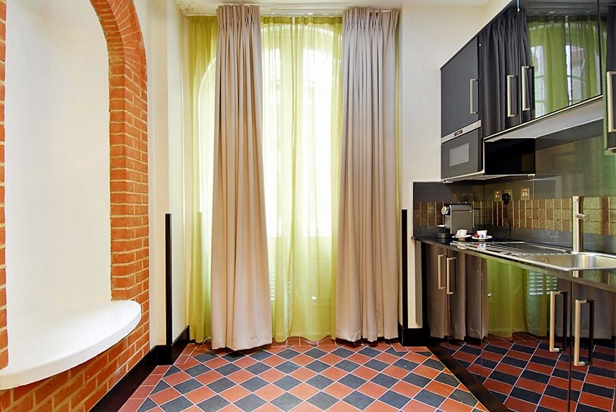 Montcalm Brewery Townhouse Hotel Лондон Екстериор снимка The photo shows a kitchen area with modern design elements. There are large, light-colored curtains hanging from the windows, allowing natural light to filter in. The walls are partially exposed brick, giving a warm texture to the room. The flooring 